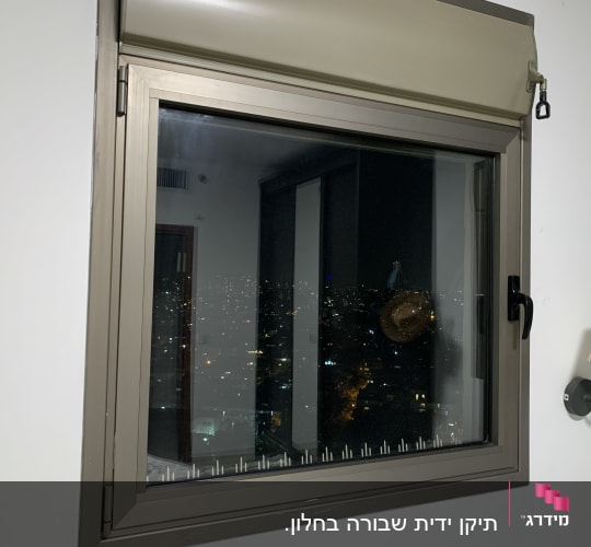 חלון עם תריס גלילה סגור חלקית